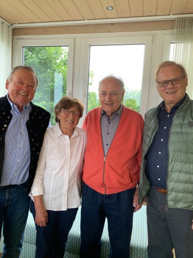 v.l. Hans, Franziska, Heinrich, Ludwig Vier ältere Menschen stehen lächelnd zusammen vor großen Fenstern.